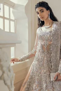 Get yourself a sweet treat, as this ensemble showcases the majestic light orange colour inscribed with lustrous embellishments. A combination of light orange attached grantly to the organza scalloped shirt heightened with silver embroidery. The shirt is intensified with tones of dabka, tilla, kora and blossoms of Resham coupled with a defined sweetheart neckline along with full sleeves. It is coordinated with a flared sharara which is embellished with floral motifs and ornamented borders. This outfit establishes a vibe of its own on your Walima day when finished with a dupatta which is framed with four-sided borders and sequins sprayed all over.
