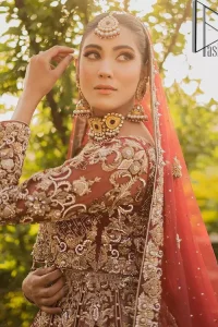 Love is in the air. A maroon blouse in maroon colour is hand-rendered in gold and is enhanced with naqshi, tilla, dabka, and kora along with the magic of zardozi. The boat shape neckline of the following blouse is pleasing to the outfit when combined with full sleeves to make your reception day more memorable. The flared lehenga in the same colours has gorgeous embroidery patterns and is paired up with a dupatta which is framed with a four-sided embellished border. It is further prominent with a sequin spray to give you the look of a model of the era.