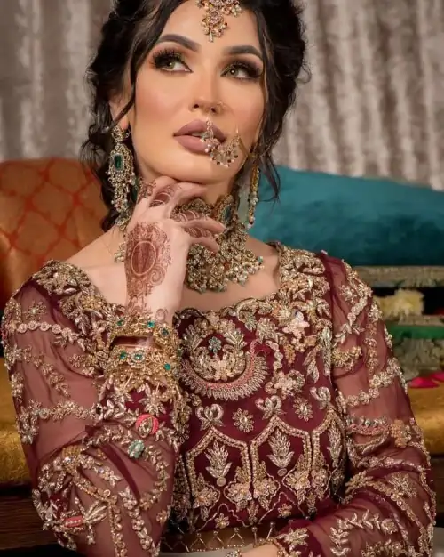 Take your style up a few notches in this elegant reception piece. A pure organza maroon fluffy lehnga is beautifully