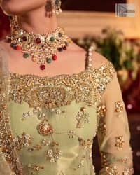 A refreshing colour palette that will make your eyes twinkle and heart sing! A pure organza short shirt in olive green is attractively hand-rendered with golden embroidery and is enhanced with naqshi, Sitara, dabka, tilla, and Zardozi. The strap neckline of this amazing shirt comes with full sleeves to make your Mehndi event more delightful and stunning. The following shirt is paired with double layered lehenga which is just in plane mode to balance the outfit. Complete this traditional look with a dupatta with sequins sprayed all over, framed with a gorgeous embellished four-sided border.