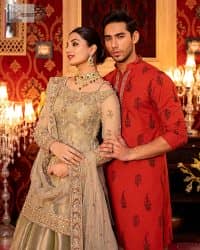 A refreshing colour palette that will make your eyes twinkle and heart sing! A pure organza short shirt in olive green is attractively hand-rendered with golden embroidery and is enhanced with naqshi, Sitara, dabka, tilla, and Zardozi. The strap neckline of this amazing shirt comes with full sleeves to make your Mehndi event more delightful and stunning. The following shirt is paired with double layered lehenga which is just in plane mode to balance the outfit. Complete this traditional look with a dupatta with sequins sprayed all over, framed with a gorgeous embellished four-sided border.