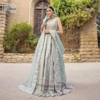 For the love of blue! A raw silk pale blue maxi with a heavy border is beautifully embroidered in silver colour. The maxi is enhanced with tilla, dabka, kora, Kundan, Sitara and detailing of resham. The round shape neckline is also beautifully decorated with silver embroidery to enhance the sleeveless style of the following maxi. It is paired up with a scalloped dupatta which is ornamented with four-sided borders and sequins sprayed all over in the same colour leaving you at the start of the Nikah event.