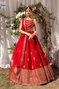 Master of artists who are the secret keepers of the canvas made the perfect shade of red for you to wear at your reception. A pure organza canvas of blouse, dipped in the richest shade of red, is adorned with dabka, sequins, tilla, kora and the magic of Resham. The following blouse is further magnified with golden embroidery with the highest attention to detail. The Round shape neckline of the blouse gives so romantic look when comes with a sleeveless style. It is paired u with flared and fluffy lehenga in silk whose bottom is heavily embellished. Complete this outfit with an organza dupatta framed with four-sided borders to be the star of the show.