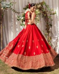Master of artists who are the secret keepers of the canvas made the perfect shade of red for you to wear at your reception. A pure organza canvas of blouse, dipped in the richest shade of red, is adorned with dabka, sequins, tilla, kora and the magic of Resham. The following blouse is further magnified with golden embroidery with the highest attention to detail. The Round shape neckline of the blouse gives so romantic look when comes with a sleeveless style. It is paired u with flared and fluffy lehenga in silk whose bottom is heavily embellished. Complete this outfit with an organza dupatta framed with four-sided borders to be the star of the show.
