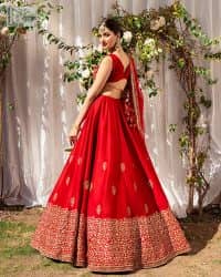 Master of artists who are the secret keepers of the canvas made the perfect shade of red for you to wear at your reception. A pure organza canvas of blouse, dipped in the richest shade of red, is adorned with dabka, sequins, tilla, kora and the magic of Resham. The following blouse is further magnified with golden embroidery with the highest attention to detail. The Round shape neckline of the blouse gives so romantic look when comes with a sleeveless style. It is paired u with flared and fluffy lehenga in silk whose bottom is heavily embellished. Complete this outfit with an organza dupatta framed with four-sided borders to be the star of the show.