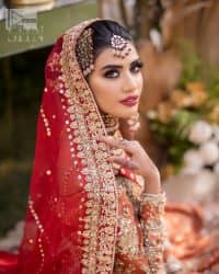 Shine bright in the sparkling ensemble from DeemasFashion. Introducing this reception outfit which begins with a rust pishwas.  This front en pishwas dipped in the richest shade of rust and is ornamented with golden embroidery which is further intensified with tilla, dabka, sequins and the real magic of zardozi. The strap neckline of the pishwas gives a unique aesthetic sense when comes with full sleeves. It is coordinated with an ivory lehenga whose border is embellished with golden embroidery. Finish this article with a dupatta framed with a four-sided embroidered border and sequin sprayed all over.