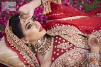 Shine bright in the sparkling ensemble from DeemasFashion. Introducing this reception outfit which begins with a rust pishwas.  This front en pishwas dipped in the richest shade of rust and is ornamented with golden embroidery which is further intensified with tilla, dabka, sequins and the real magic of zardozi. The strap neckline of the pishwas gives a unique aesthetic sense when comes with full sleeves. It is coordinated with an ivory lehenga whose border is embellished with golden embroidery. Finish this article with a dupatta framed with a four-sided embroidered border and sequin sprayed all over.