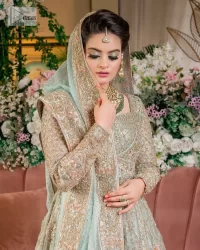 Unique embroidery designs to add some sparkle to your style on your Nikah! Light blue angrakha maxi with delicate multiple colour embroideries and intricate hand embellishments of tilla, dabka, kora, Kundan and crystals on the classic silhouette. Designed to flaunt your best features, the full sleeves carry beautiful embroidery with a square neckline. The following maxi along with the back train lehenga gives this outfit a unique look. Paired with a dreamy dupatta framed with embellished borders, this look is the epitome of ethereal and easy elegance.