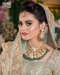 Unique embroidery designs to add some sparkle to your style on your Nikah! Light blue angrakha maxi with delicate multiple colour embroideries and intricate hand embellishments of tilla, dabka, kora, Kundan and crystals on the classic silhouette. Designed to flaunt your best features, the full sleeves carry beautiful embroidery with a square neckline. The following maxi along with the back train lehenga gives this outfit a unique look. Paired with a dreamy dupatta framed with embellished borders, this look is the epitome of ethereal and easy elegance.