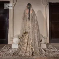 Unravel your inner density with our ivory nikah outfit. DeemasFashion presents this outfit which is embellished with light golden embroidery that further intensifies with tilla, dabka, kora, Kundan and the real magic of Zardozi. The ivory short shirt has boat shape neckline that is the epitome of royalty and grace. In addition to this, the embellished full sleeves also give a stunning touch to the shirt. It is coordinated with scalloped sharara making it a perfect choice to pair with the short shirt. Finish this outfit with a dupatta framed with four-sided embellished borders that gives you an impressive appearance on the Big day.