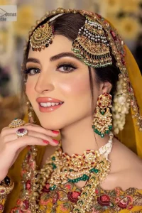 Take your style quotient up a few notches in this exquisite mehndi outfit! ]The maxi in mustard colour is a ravishing bridal attire with a magnificent elite and classy appearance. Gorgeous and glamorous multiple-colour embroideries enhance the showiness of this maxi.  It is further intensified with tilla, dabka, kora, Kundan and details of thread embroidery. Full sleeves, boat shape neckline and sparkling work make it a perfect traditional wear. It is coordinated with a scalloped dupatta in the same colour which is embellished with four-sided borders and floral motifs all over to make this outfit unique and aesthetic.