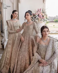 Make your Qabool Hai moment more memorable with this outfit by DeemasFashion. A dreamy statement of this dress proffers a soft pink hue with glamorous silver and golden embroidery.  It is further enhanced with tilla, dabka, kora, Kundan and the real magic of zardozi. V neckline enhances the overall glamour of this masterpiece. Intricate designs and fine details on the sleeves give a perfect finishing look to this maxi. The maxi is layered over a meticulously handcrafted lehnga which is bold enough to stand out in the crowd. Finish this article with a dupatta which is ornamented with four-sided borders and sequins sprayed all over which is a unique piece for your Nikah look.