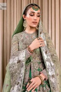 Dive into the world of ultimate allurement with this exquisitely embellished Mehndi outfit that depicts intricate glam with an elegant statement detailing. The maxi in teal green colour is heavily adorned with silver embroidery which involves tilla, dabka, kora, Kundan and the real magic of Zardozi. Further, the high neckline and full sleeves add extra glamour to this outfit. It is organized with magnificent lehenga in the same colour emblazoned with intricate gleaming embroidery which enhances the charm of this Dress. The tiny floral motifs also spread on the lehenga. Complete this article with a dupatta framed with four-sided borders and tiny floral motifs all over to make your day charming.