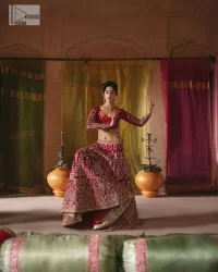 We are Introducing a wine red blouse and lehenga to our wide range of charming bridal dresses. The Pakistani reception Lehenga is an amalgamation of contemporary and traditional art which is decorated with golden embroidery. The embroidery is further enhanced with tilla, dabka, kora, Kundan and detailing of zardozi. It is paired up with a wine red blouse which is adorned with tiny floral motifs. The full sleeves of the blouse are heavily embellished to increase the beauty of the outfit. Further, the square neckline makes this blouse a unique masterpiece. Finish this with a dupatta with a four-sided embellished border and floral motifs all over.