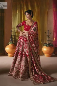 We are Introducing a wine red blouse and lehenga to our wide range of charming bridal dresses. The Pakistani reception Lehenga is an amalgamation of contemporary and traditional art which is decorated with golden embroidery. The embroidery is further enhanced with tilla, dabka, kora, Kundan and detailing of zardozi. It is paired up with a wine red blouse which is adorned with tiny floral motifs. The full sleeves of the blouse are heavily embellished to increase the beauty of the outfit. Further, the square neckline makes this blouse a unique masterpiece. Finish this with a dupatta with a four-sided embellished border and floral motifs all over.
