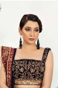 DeemasFashion presents this Party outfit which is an embellished masterpiece that wins everyone's hearts at the very first glance with its charm and elegance. The blouse in the oxford blue colour has laden with golden embroidery which makes this attire a head-turning masterpiece. Further, the square neckline is fully embellished with tilla, dabka, kora, Kundan, and pearls that is giving it a magical look. The strap neckline makes this outfit a little romantic but super charming. Paired up with a brocade lehenga which is embellished with a floral pattern to make your day. Complete this article with a dupatta, framed with a four-sided border.