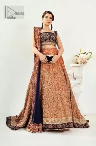 DeemasFashion presents this Party outfit which is an embellished masterpiece that wins everyone's hearts at the very first glance with its charm and elegance. The blouse in the oxford blue colour has laden with golden embroidery which makes this attire a head-turning masterpiece. Further, the square neckline is fully embellished with tilla, dabka, kora, Kundan, and pearls that is giving it a magical look. The strap neckline makes this outfit a little romantic but super charming. Paired up with a brocade lehenga which is embellished with a floral pattern to make your day. Complete this article with a dupatta, framed with a four-sided border.