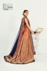 DeemasFashion presents this Party outfit which is an embellished masterpiece that wins everyone's hearts at the very first glance with its charm and elegance. The blouse in the oxford blue colour has laden with golden embroidery which makes this attire a head-turning masterpiece. Further, the square neckline is fully embellished with tilla, dabka, kora, Kundan, and pearls that is giving it a magical look. The strap neckline makes this outfit a little romantic but super charming. Paired up with a brocade lehenga which is embellished with a floral pattern to make your day. Complete this article with a dupatta, framed with a four-sided border.