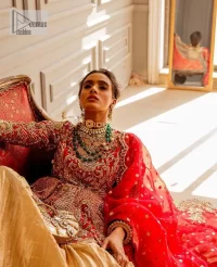The magic of luxurious romantic outfits at your reception, giving out love and letting it come in. The Beautiful bright red short frock is adorned with classy golden embroidery and will look breathtaking on the traditional bride. The boat shape neckline makes this frock a glamorous choice to pair with the classy golden crushed lehenga. In addition to this, the following frock is enhanced with tilla, dabka, kora, Kundan and the real magic of zardozi. Crushed Lehenga paired with the Embellished frock enhances the overall Royal look of the outfit. The perfect stitching and crushed style make this Lehenga your first-ever priority. Complete this article with a scalloped dupatta that is embellished with four-sided borders and sequins sprayed all over.