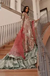 The latest elegant embroidered maxi in peach colour with magnificence embroidered work. The front open maxi is attractively laden with light golden embroidery to make this masterpiece unique and charming. Purely balanced raw silk maxi is presented with an ethereal blend of Resham, naqshi, kora, dabka and Mukesh carved with stones. Full Sleeves of the following maxi are also heavily embroidered. The round neckline gives it a magical look. It is coordinated with crushed lehenga in a pistachio green colour to create a ravishing Nikkah bride look. This crushed lehenga is paired with embroidered dupatta detailed with a splash of sequins and embroidered borders.