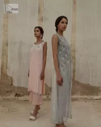 Balancing outfit lovers here’s your style treat! The handsome and charming steel grey attire is an epitome of elegance and royalty that gives you a head-turning appearance on the party occasion. The front open gown is laden with silver embroidery that is further enhanced with tilla, dabka, kora, Kundan and luxuries of crystals. The round neckline of this gown is emblazoned with luxury designs and embroidery. In addition to this, the sleeveless style makes this article a masterpiece. Paired up with straight trousers to balance the look of this exquisite article.