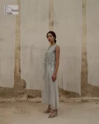 Balancing outfit lovers here’s your style treat! The handsome and charming steel grey attire is an epitome of elegance and royalty that gives you a head-turning appearance on the party occasion. The front open gown is laden with silver embroidery that is further enhanced with tilla, dabka, kora, Kundan and luxuries of crystals. The round neckline of this gown is emblazoned with luxury designs and embroidery. In addition to this, the sleeveless style makes this article a masterpiece. Paired up with straight trousers to balance the look of this exquisite article.