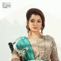 Celebrate your party with a bang and steal everyone's heart. The beautiful blouse in teal green shade comes in organza fabric. The boat shape neckline and full sleeves of this organza blouse are emblazoned with luxury details and intricate designs. Graceful golden embroidery that enhances with tilla, dabka, kora, Kundan, Zardozi and crystals to give a perfect finishing look to the blouse. It is organized with a back train lehenga which is heavily adorned with embroidery to make this masterpiece super aesthetic. Finish this outfit with a scalloped dupatta having four-sided embellished borders for a fine finishing look.