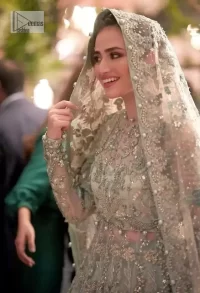 The magic reflects in every piece of this nikah wear. DeemasFashion presents a stunning outfit in an aqua-blue colour. A heavenly designed aqua blue maxi on an organza base serves as a canvas for spellbinding embellishments of gold, tilla, dabka, kora, Kundan and sequins. It is highlighted with silver embroidery to gain the spotlight of the show. The jewel neckline and full sleeves are rendered with beautiful floral patterns and embroidered borders. It is organized with a lehenga in the same colour, adorned with beautiful embroidery giving the perfect final touch. Complete this outfit with a dupatta in the same colour. This dupatta is adorned with floral motifs and silverwork. The embellished borders of this delicate net dupatta make this article your foremost priority.