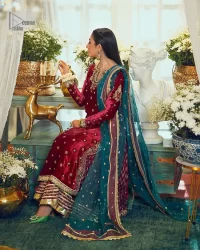Dreamy details that scream crimson. The day outfits you need to shine your light. DeemasFashion presents this party wear which includes a long shirt, sharara and dupatta. The deep crimson shirt gives that air of regality with its stunning work with hints of tilla, dabka, kora, and Kundan scattered with champagne-mixed stones to balance the tones. The following long silhouette velvet shirt features zari and zardozi embroidery details on the embellished neckline. Further, the full sleeves are also decorated with floral motifs. It is systemized with sharara in the same colour to balance the royal look. Finish this article with a dupatta in green colour which is adorned with tiny floral motifs all over to brighten the day.