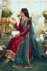 Dreamy details that scream crimson. The day outfits you need to shine your light. DeemasFashion presents this party wear which includes a long shirt, sharara and dupatta. The deep crimson shirt gives that air of regality with its stunning work with hints of tilla, dabka, kora, and Kundan scattered with champagne-mixed stones to balance the tones. The following long silhouette velvet shirt features zari and zardozi embroidery details on the embellished neckline. Further, the full sleeves are also decorated with floral motifs. It is systemized with sharara in the same colour to balance the royal look. Finish this article with a dupatta in green colour which is adorned with tiny floral motifs all over to brighten the day.