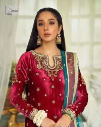 Dreamy details that scream crimson. The day outfits you need to shine your light. DeemasFashion presents this party wear which includes a long shirt, sharara and dupatta. The deep crimson shirt gives that air of regality with its stunning work with hints of tilla, dabka, kora, and Kundan scattered with champagne-mixed stones to balance the tones. The following long silhouette velvet shirt features zari and zardozi embroidery details on the embellished neckline. Further, the full sleeves are also decorated with floral motifs. It is systemized with sharara in the same colour to balance the royal look. Finish this article with a dupatta in green colour which is adorned with tiny floral motifs all over to brighten the day.