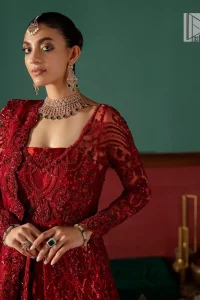Deep red is just associated with love and romance! For a more lovely and romantic look on your big day just buy this reception wear. The deep red maxi is heavily adorned with intricate hand-worked of tilla, dabka, kora, Kundan and Zardozi in the shade of red which is sure to make you look glamorous on your big day. The square neckline merges rich traditions with modern style. Further, the full sleeves of the maxi also add more charms. It is organized with a back train lehenga which is also embellished and highlighted with floral motifs. Complete this super romantic look with a dupatta which is encrusted with four-sided embellished borders and floral motifs sprinkled all over. 