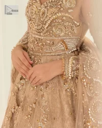 Presenting elegance personified glamorous formal nikah outfit. A heavenly-designed light golden maxi on an organza base serves as a canvas for spellbinding embellishments of antique gold, tilla, dabka, kora, Kundan and sequins. The sweetheart neckline makes this outfit unique and priceless. Furthermore, the following flawed maxi has three-quarter sleeves. It is paired with a plain lehenga and a dupatta in the same colour. The dupatta is adorned with carefully placed sequin spray and embellished four-sided borders for more calm and charm.