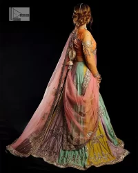 Fun colours, fresh you.  This breathtaking blouse in light orange colour is gracefully adorned with hand-crafted embellishments and lavish golden work creating a magnificent masterpiece to give you your desired appearance. The boat shape neckline of the mehndi wear is the epitome of beauty. Further, the embellished three-quarter is adorned with lavish designs and fine details making it a perfect choice to pair with the lehenga. It is organized with lehenga having multi-colour panels to give you a fresh and rainbow look on your mehndi. The lehenga is also adorned with tilla, dabka, kora, Kundan and the real magic of Zardozi. Complete this article with a dupatta, framed with four-sided borders and floral motifs on pallu to make your day Funday.