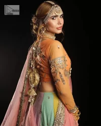 Fun colours, fresh you.  This breathtaking blouse in light orange colour is gracefully adorned with hand-crafted embellishments and lavish golden work creating a magnificent masterpiece to give you your desired appearance. The boat shape neckline of the mehndi wear is the epitome of beauty. Further, the embellished three-quarter is adorned with lavish designs and fine details making it a perfect choice to pair with the lehenga. It is organized with lehenga having multi-colour panels to give you a fresh and rainbow look on your mehndi. The lehenga is also adorned with tilla, dabka, kora, Kundan and the real magic of Zardozi. Complete this article with a dupatta, framed with four-sided borders and floral motifs on pallu to make your day Funday.