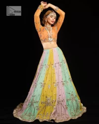 Fun colours, fresh you.  This breathtaking blouse in light orange colour is gracefully adorned with hand-crafted embellishments and lavish golden work creating a magnificent masterpiece to give you your desired appearance. The boat shape neckline of the mehndi wear is the epitome of beauty. Further, the embellished three-quarter is adorned with lavish designs and fine details making it a perfect choice to pair with the lehenga. It is organized with lehenga having multi-colour panels to give you a fresh and rainbow look on your mehndi. The lehenga is also adorned with tilla, dabka, kora, Kundan and the real magic of Zardozi. Complete this article with a dupatta, framed with four-sided borders and floral motifs on pallu to make your day Funday.