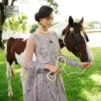 Lilac article on your Big day is like a pro. This lilac front open gown in the lilac shade is the epitome of royalty and grace. The gorgeous gown is adorned with silver dabka, pearls,tilla, kora, Kundan, zardozi and the real magic of beads. It is prominent with silver embroidery. The following gown has a V shape neckline to make this outfit remarkable. Further, the beautiful embroidery is adorned on full sleeves. The fully embellished lilac Gown will look perfect when paired with a set of plain lehenga choli. It is organized with a dupatta framed with four-sided borders and tiny floral motifs all over to gain pro magic.