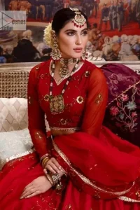 Statement suiting in red. This red blouse comes with a lehenga and dupatta in premium fabric quality. The blouse is beautifully decorated with fine embroidery work accompanied by iridescent sequins, tilla, dabka, kora and Zardozi. Furthermore, beautiful artistry on the neckline is highlighted with golden embroidery accompanied by cutwork counting more to the elegance of this luxurious attire. It is organized with a flared lehenga in the same colour. This embroidered lehenga comes is very neatly stitched and decorated with lavish embroidery and minimal floral motifs making this dreamy attire look heavenly and your ultimate priority. Complete this reception wear with a dupatta framed with four-sided embellished borders that is your favourite statement on your big day.