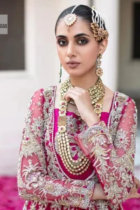 Be a dream vision in this floral shocking pink article. The shocking pink maxi is a breathtaking masterpiece that wins everyone's hearts at the very first glance. The stunning details of silver embroidery which includes tilla, dabka, kora, Kundan and zardozi give a royal touch to this scalloped maxi. The front open style and sweetheart neckline come together to make this outfit lovely and charming. The full sleeves give a glamorous touch to this perfectly maxi. It is paired with Lehenga to create a lavish look. The Lehenga has a huge flare and is also embellished with beautiful embroidery. Complete this walima article with a grey dupatta in a scalloped design which is adorned with a four-sided heavy embellishment. 