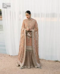 This ensemble is an absolute vibe with a tempting design on a beautiful base!  This beautiful party wear is designed in soft brown colour which is modern yet classy. The short shirt is adorned with silver embroidery which is further enhanced with tilla, dabka, kora, Kundan and the details of Zardozi. The beautiful tussles also hang on the bottom of the embellished neckline to make it a perfect choice for everyone Further, the floral patterns on full sleeves also intensify the charms of the outfit. It is coordinated with a sharara to balance the overall look. Complete this with a dupatta embellished with a four-sided border and floral jaal all over.
