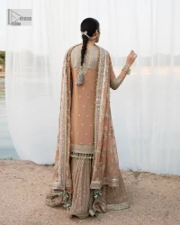 This ensemble is an absolute vibe with a tempting design on a beautiful base!  This beautiful party wear is designed in soft brown colour which is modern yet classy. The short shirt is adorned with silver embroidery which is further enhanced with tilla, dabka, kora, Kundan and the details of Zardozi. The beautiful tussles also hang on the bottom of the embellished neckline to make it a perfect choice for everyone Further, the floral patterns on full sleeves also intensify the charms of the outfit. It is coordinated with a sharara to balance the overall look. Complete this with a dupatta embellished with a four-sided border and floral jaal all over.