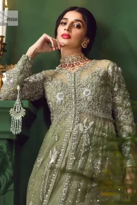 Experience the joy of a wedding in dreamy ensembles. Bringing old-world charm into your festive ensembles, it is a front open scalloped maxi intricately embellished with fine silver embroidery, crystals, tilla, dabka, kora and sequin. The full sleeves of the maxi make it an expression of timeless elegance. In addition to this, the V shape neckline makes this masterpiece unique and priceless. Paired with a long border embellished scalloped dupatta it all comes together to create a luxuriously chic look. The dupatta is also embellished with tiny floral motifs and sequins spray. Complete this party wear with a simple lehenga in the same colour to balance the overall look of the outfit.