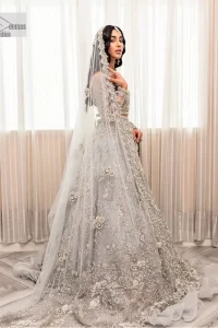 Enter the world of allurement with steel grey, a gorgeous go-to dress for nikah to make you look classy and fabulous at the same time! The delicate details of this gorgeous bridal dress are from exquisite patterns observed in silver embroidery which is prominent with tilla, dabka, kora, Kundan, Zardozi and the real magic of crystals. The house has V shape neckline to make this masterpiece a little romantic and classy. Further, full sleeves are fully designed with fantastic floral patterns spread all over. It is paired with a lehenga having frilled to complete the lavish look of this fully embellished nikah wear. Complete this article with a dupatta adorned with four-sided embellished borders and sequins sprayed all over.