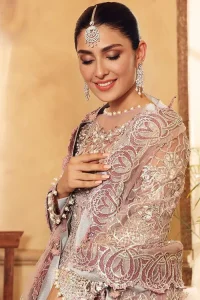 This elegantly poised ensemble defines nikah fashion in its most refined form! The scalloped maxi in premium quality is hand-embellished with beaming adornments and multiple colour embroidery. It is further enhanced with tilla, dabka, kora, Kundan and the real magic of crystals. Stunning designs on full sleeves and premium details on the illusion neckline make it an exquisite masterpiece. It is combined with sharara to balance the most demanding and delicate look. Finish this nikah wear with a dupatta in the same colour. The borders of this dupatta are heavily embellished, giving a perfectly glamorous look to the beautiful attire.