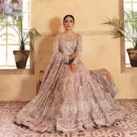 This elegantly poised ensemble defines nikah fashion in its most refined form! The scalloped maxi in premium quality is hand-embellished with beaming adornments and multiple colour embroidery. It is further enhanced with tilla, dabka, kora, Kundan and the real magic of crystals. Stunning designs on full sleeves and premium details on the illusion neckline make it an exquisite masterpiece. It is combined with sharara to balance the most demanding and delicate look. Finish this nikah wear with a dupatta in the same colour. The borders of this dupatta are heavily embellished, giving a perfectly glamorous look to the beautiful attire.