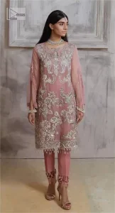 Make a style statement in this beautiful tea-pink canvas. The heavy shirt comes in a tea-pink colour and is gracefully emblazoned with silver embroidery. Hand-crafted details of sequins, tilla, dabka, kora and Zardozi give a glamorous touch to this beautiful party wear. Further, the crystalline hanging also makes this masterpiece unique and gives you a royal look. The round neckline also adds beauty to the outfit. It is paired up with trousers to balance the overall outfit.