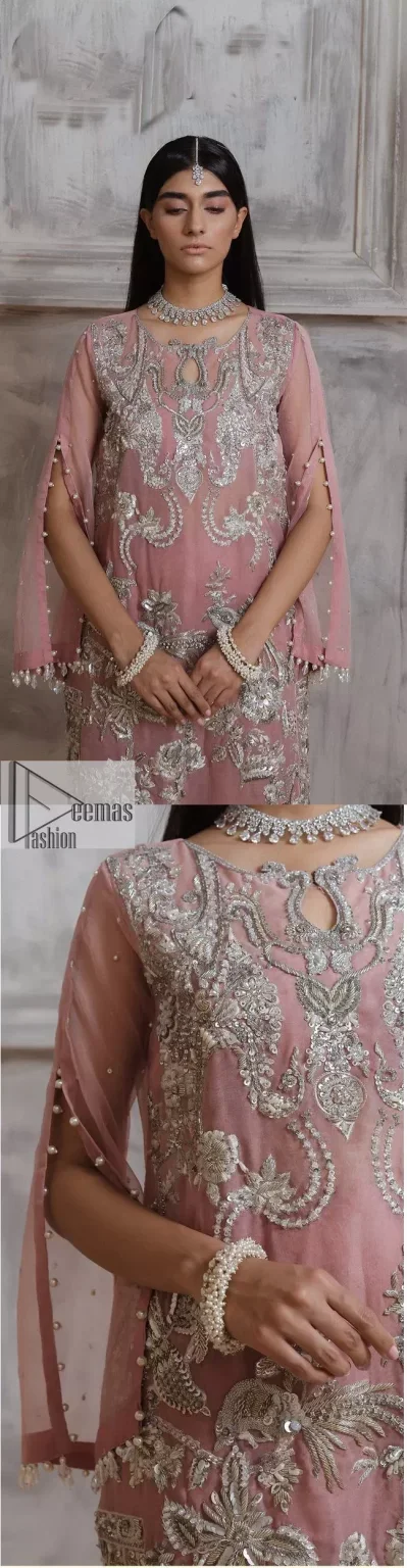 Make a style statement in this beautiful tea-pink canvas. The heavy shirt comes in a tea-pink colour and is gracefully emblazoned with silver embroidery. Hand-crafted details of sequins, tilla, dabka, kora and Zardozi give a glamorous touch to this beautiful party wear. Further, the crystalline hanging also makes this masterpiece unique and gives you a royal look. The round neckline also adds beauty to the outfit. It is paired up with trousers to balance the overall outfit.