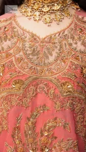 It's an aesthetic kinda mood. The long shirt in the wondrous peach colour is composed of ethnic handworked details and gleaming embellishments rendered artistically on a Jamawar canvas. The long shirt is layered with embroidered details with an enhanced V neckline and borders. The beautiful shirt is prominent with tilla, dabka, kora, Kundan and Zardozi in gold colour. Further, the intricate floral patterns on full sleeves make this outfit crazier. Complementing the shirt with gharara with elaborated borders depicts a perfect contemporary vibe.