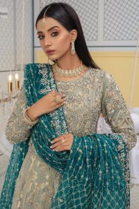 Embellishment is on the rise! The elegant front open maxi is heavily embellished in work of tilla, sequins, dabka, Zardozi, Kundan and kora work. The magnificent maxi is further highlighted with silver embroidery on the front and backside. Further, the full sleeves of the dress come with attractive embellishments. The round neckline makes this masterpiece more unique and charming. This nikah outfit is coordinated with a dupatta in teal green colour framed with a four-sided border and sparkling sequins all over that are on the peak in modern style.