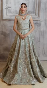 Get this ever-trending floral walima outfit.  Keep it romantic and fantastic with the DeemasFashion latest articles! The soft green blouse is gracefully embellished with silver and gold embroidery that gives you a head-turning appearance on the wedding day. The blouse is enhanced with tilla, dabka, kora, Kundan, and crystals. The off-shoulder neckline of the blouse makes this stunning attire an epitome of royalty and grace. It is paired with a flared lehenga that is also adorned with embroidery to make your day fantastic. Complete this article with a dupatta framed with four-sided embellished borders and sequins sprayed all over.